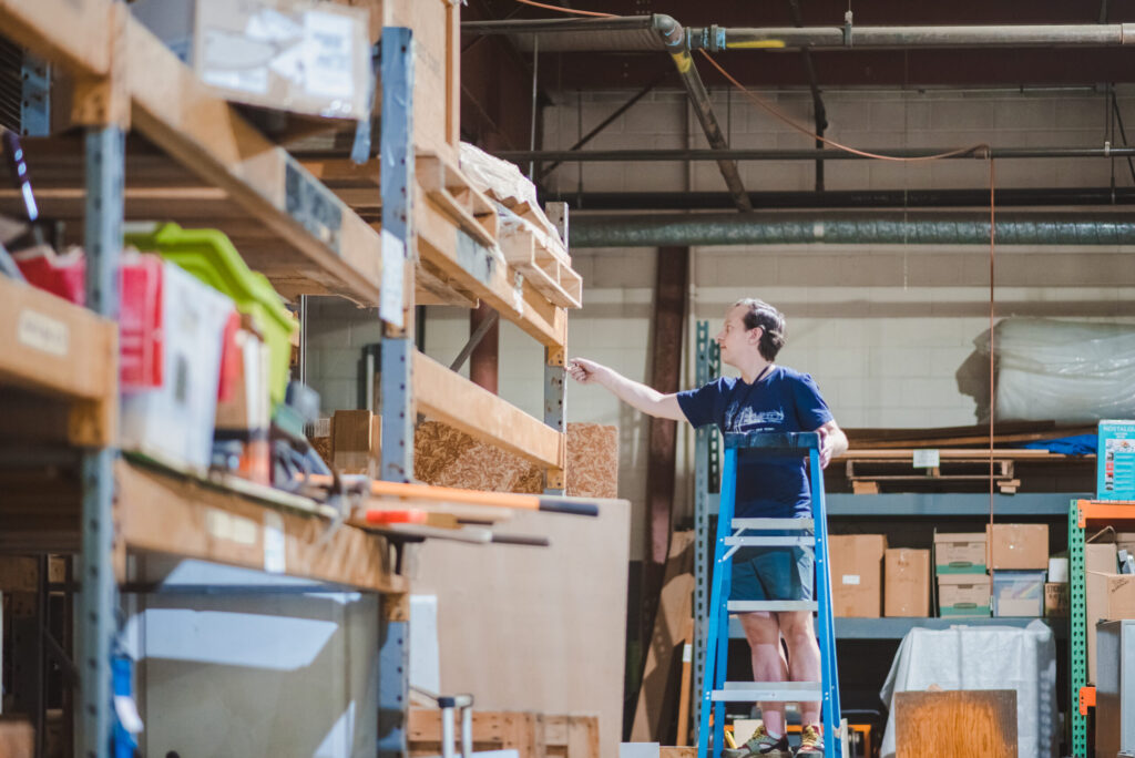 A Cville Tool Library volunteer retrieves something from a shelf