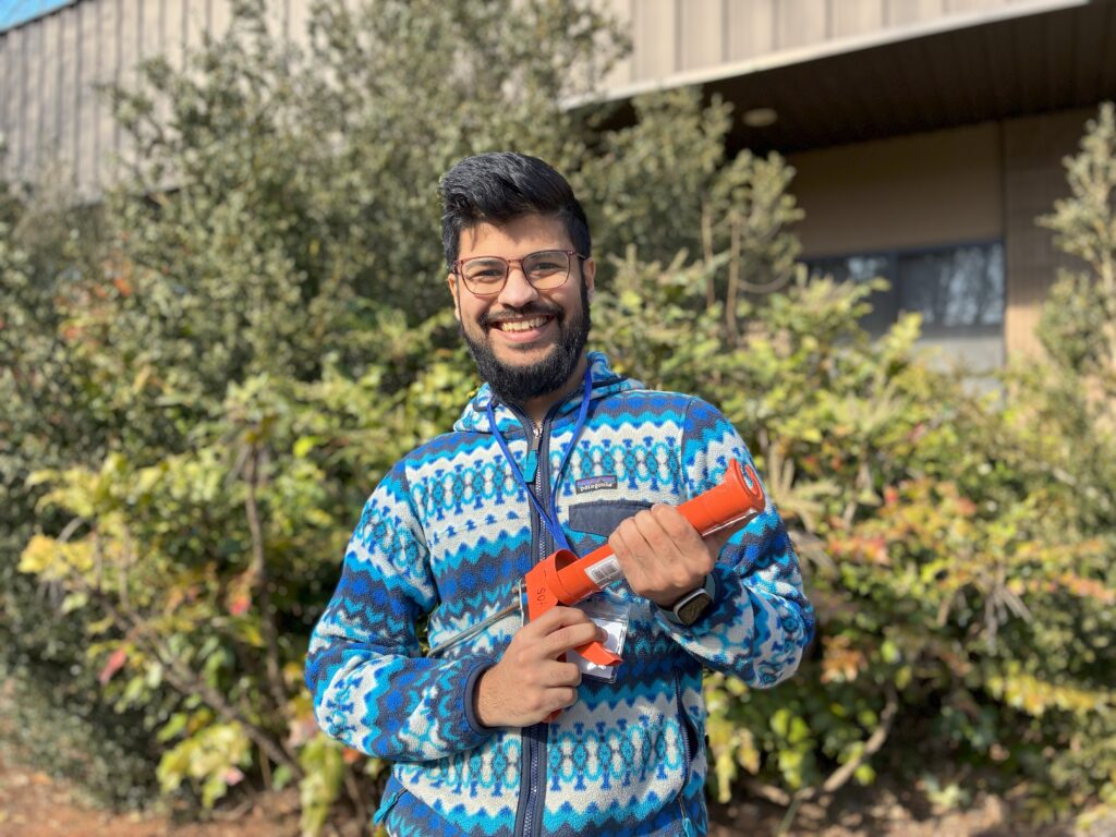 Librarian Devang holding a caulk gun