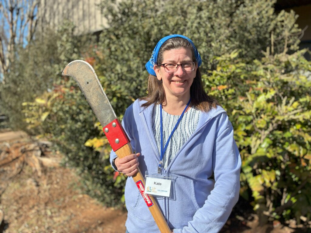 Librarian Kate holding a pole saw